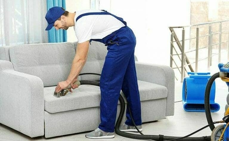 young professional vacuuming a couch