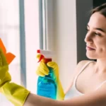 woman cleaning up her windows with a cloth mop