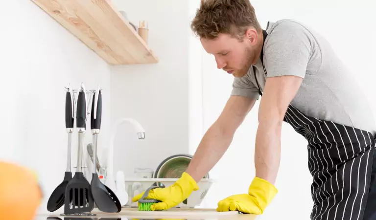 young man disinfecting a kitchen surface