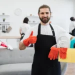 Portrait of bearded caucasian man cleaning worker holding bucket with detergents