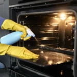 Close up of caucasian woman cleaning oven at home